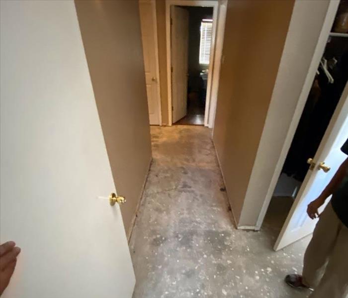 hallway with flooring ripped up and white walls
