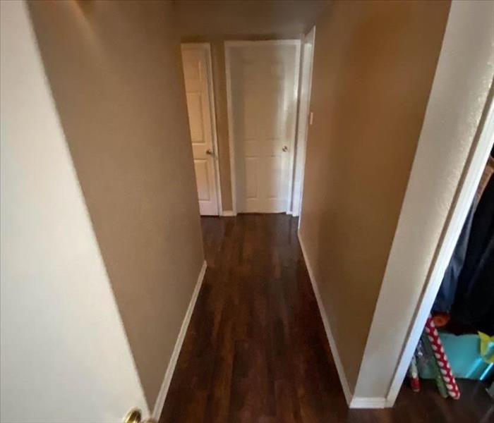 Hallway with dark wood floors and white walls